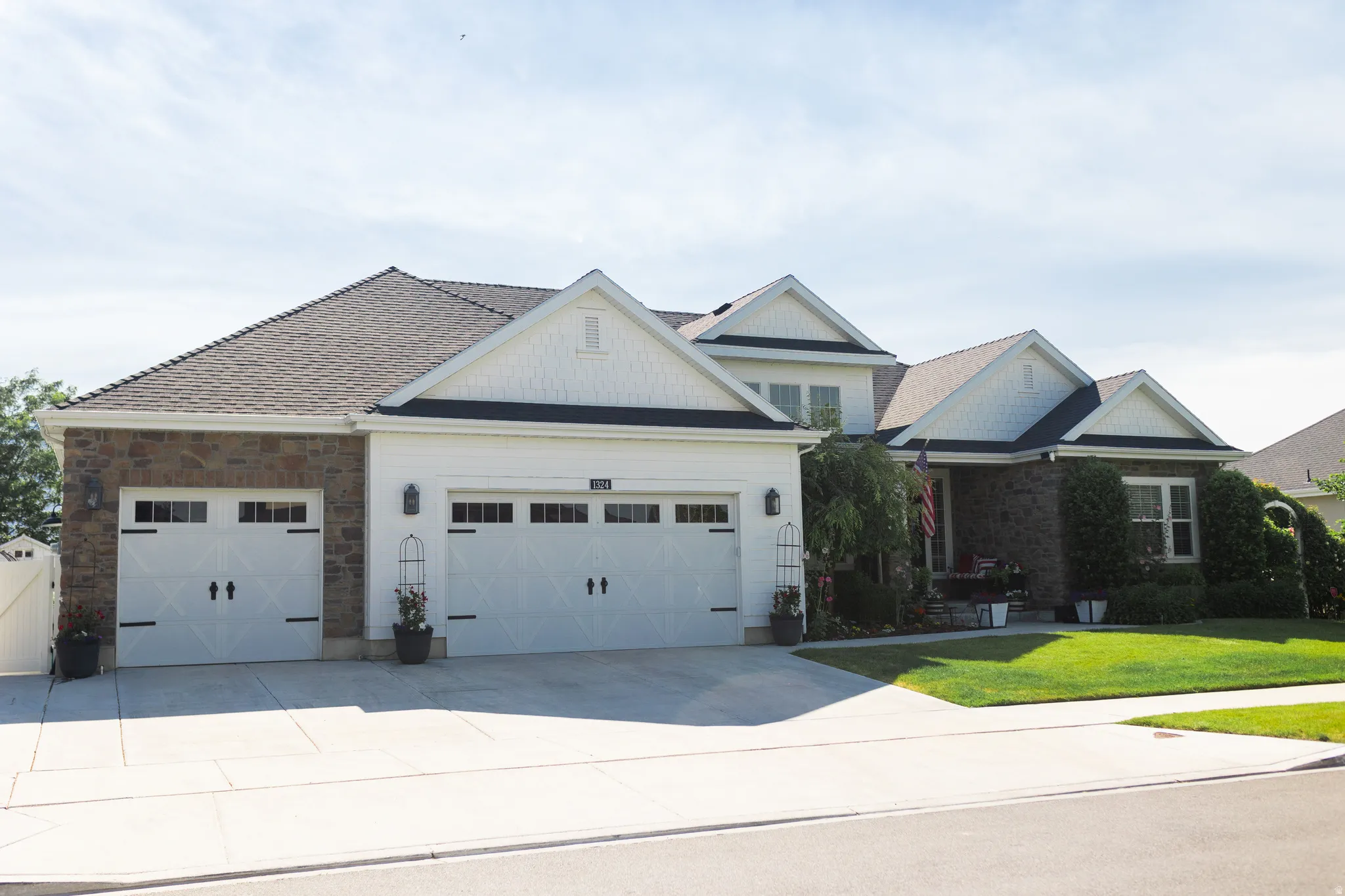 Multi-level residence featuring a combination of stone and white siding