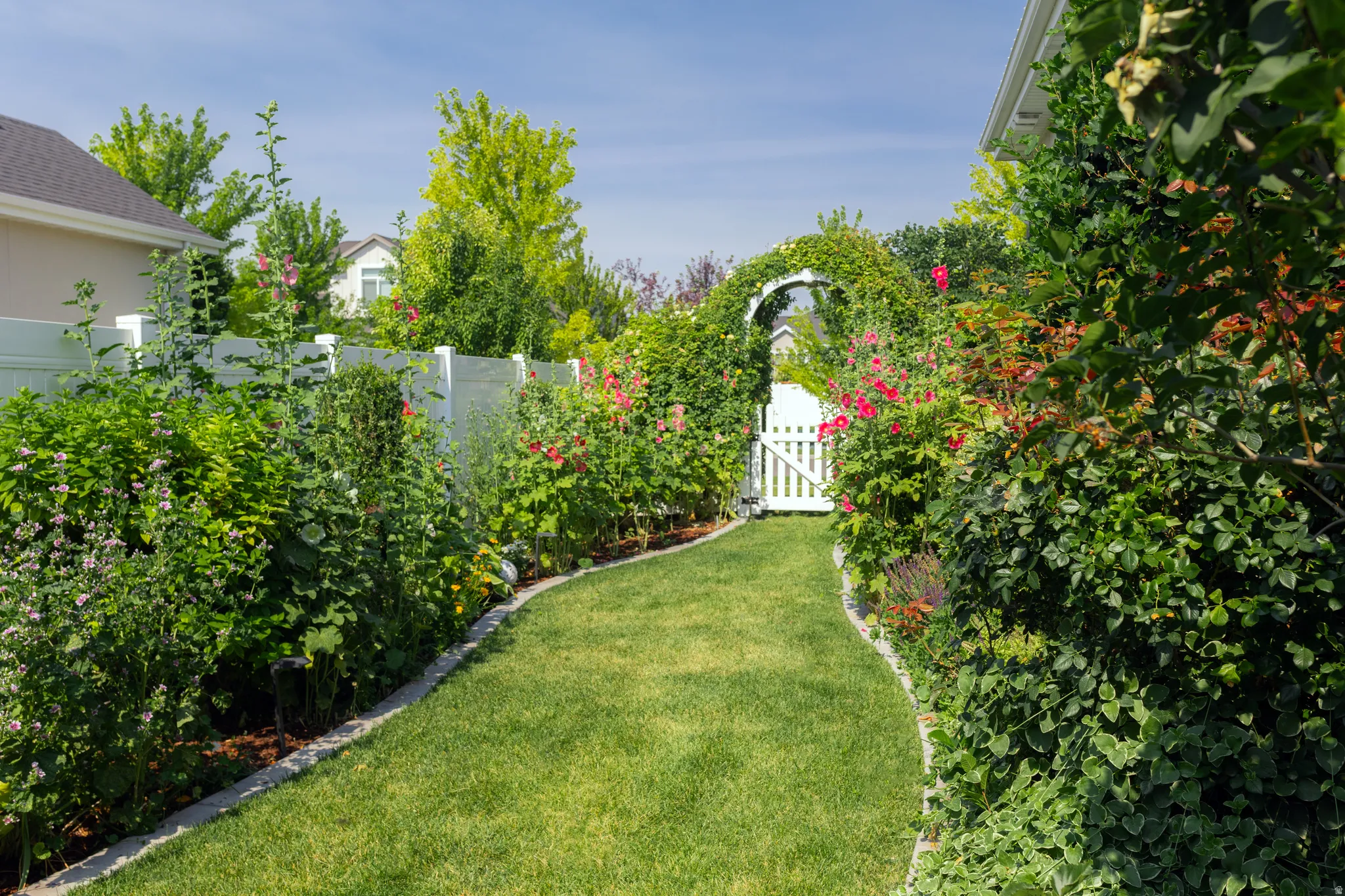South side of home leading to backyard with mature garden beds.