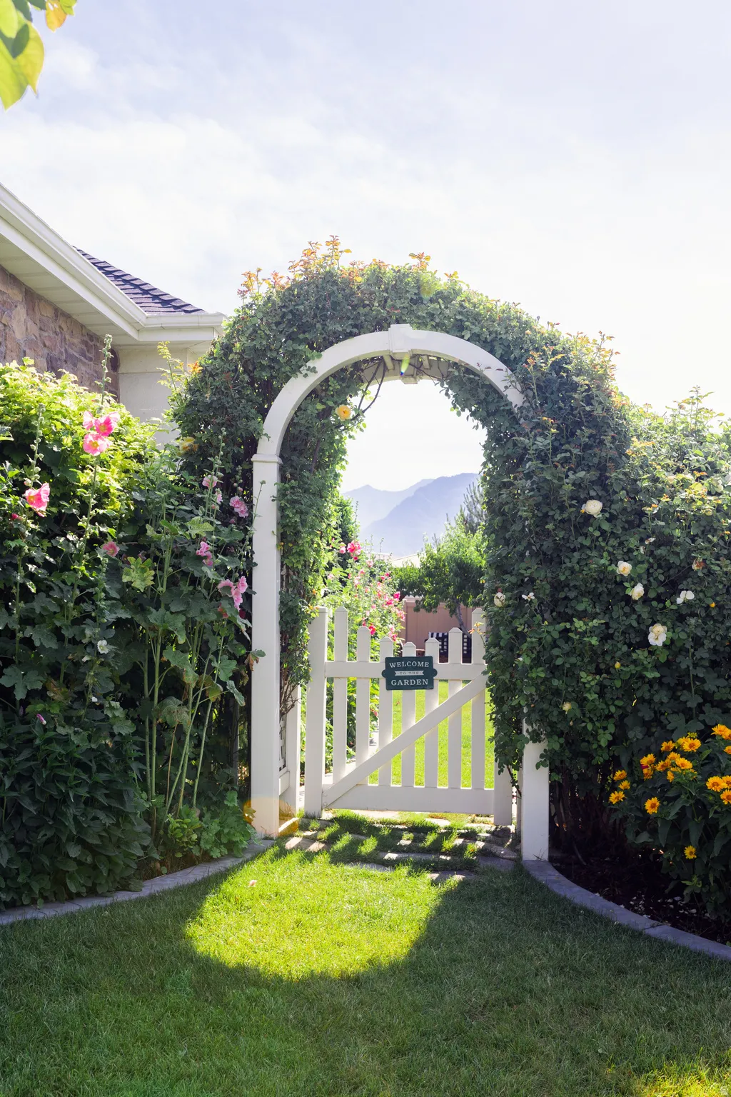 Entrance to backyard, south side of home. Climbing roses over an arched gate. Fully fenced yard.