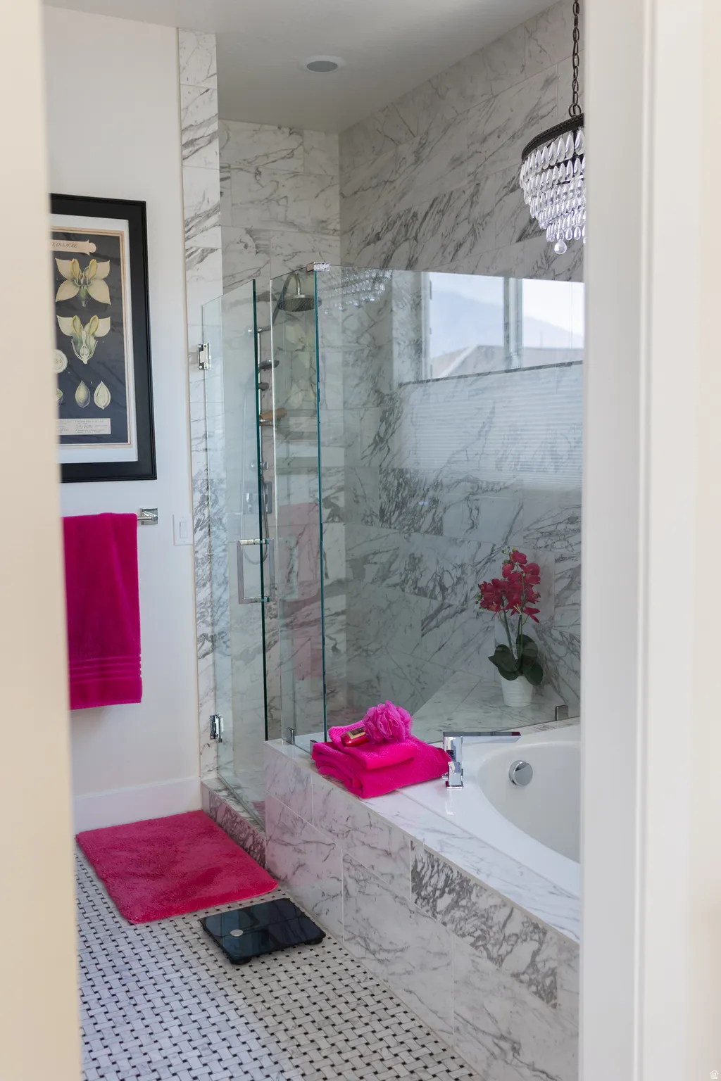 Spa-inspired primary bathroom featuring a glass-enclosed shower with full-height marble-finish tile, a built-in soaking tub with marble-finish surround, and mosaic tile flooring