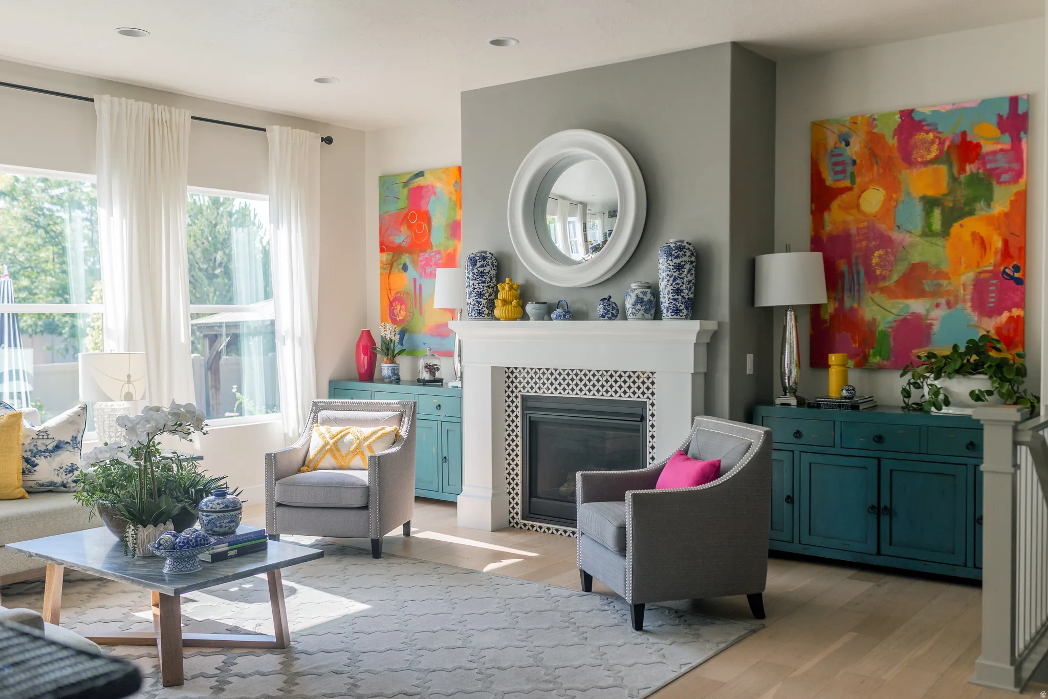 Living area featuring a white mantel fireplace with a dark firebox, light wood-finish flooring, recessed lighting, and large windows