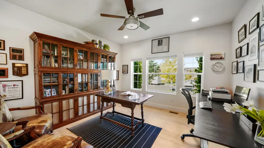 Bright room featuring light wood-finish flooring, recessed lighting, and a ceiling fan