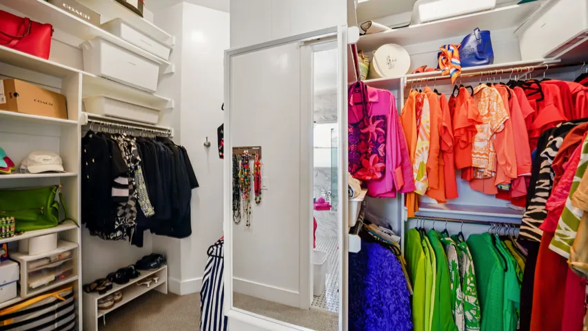 Custom closet system featuring multiple hanging rods, integrated shelving, and shoe storage