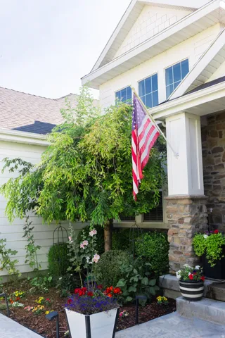Stone veneer accents, white siding, and a gabled roofline define the exterior
