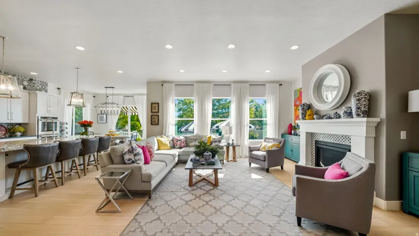 Open-concept living space featuring hardwood flooring, recessed ceiling lighting, and multiple large windows with natural light