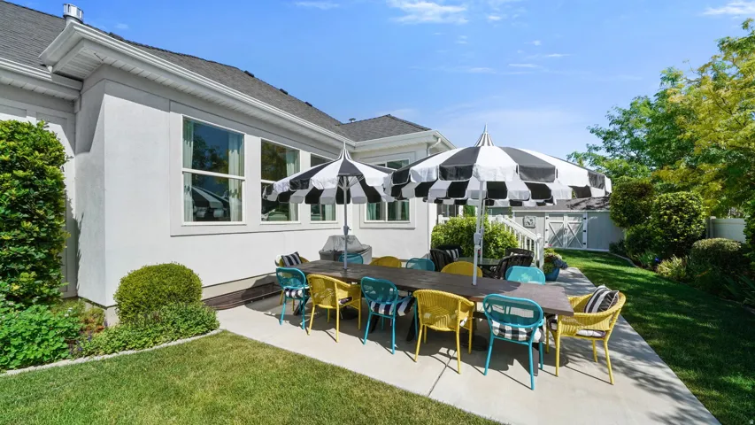 Expansive concrete patio area with a manicured lawn and mature landscaping