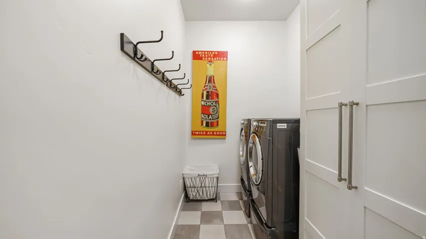 Dedicated utility space featuring checkerboard tile flooring, white walls, and built-in closet doors with brushed nickel hardware