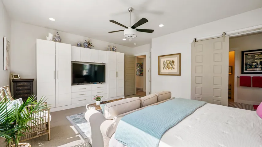 Bedroom featuring a contemporary ceiling fan, recessed lighting, and a built-in media center with integrated storage
