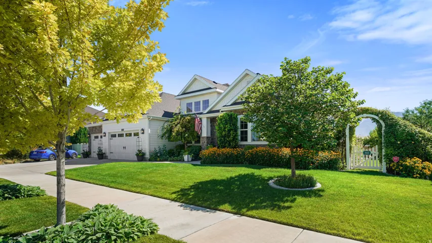 Charming two-story residence featuring a welcoming front elevation with stone and siding accents, two-car attached garage, and a professionally landscaped front yard