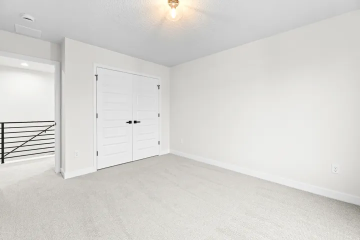 Carpeted room with white walls and a contemporary light fixture