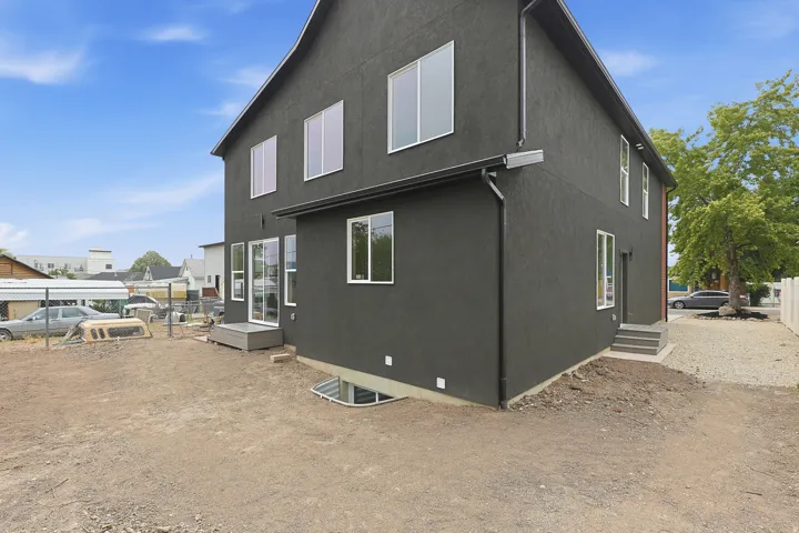 Modern exterior with dark stucco siding and white-framed windows