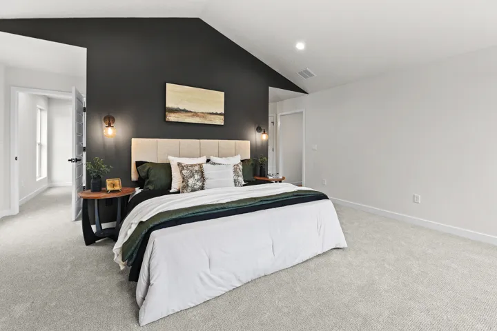 Spacious room featuring vaulted ceilings, recessed lighting, and soft carpet flooring