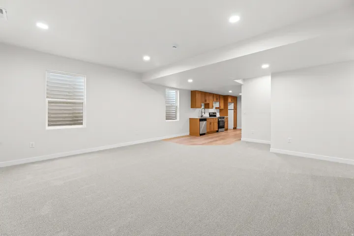 Open-concept living area with light gray carpet and recessed lighting