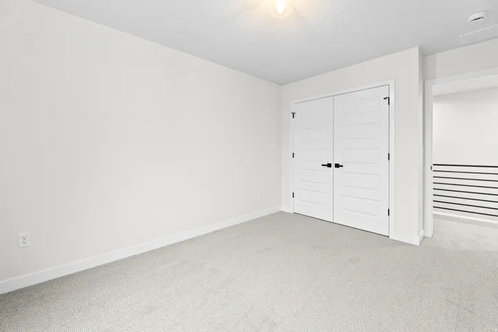 Neutral-toned room featuring light gray carpeting and white walls