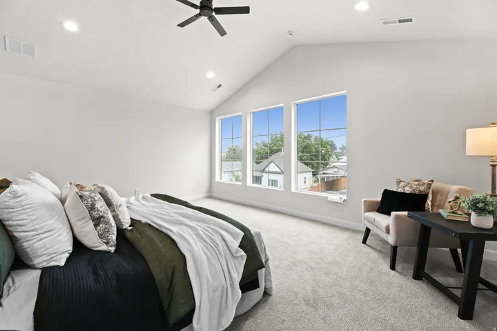 Vaulted ceiling with a black ceiling fan and recessed lighting