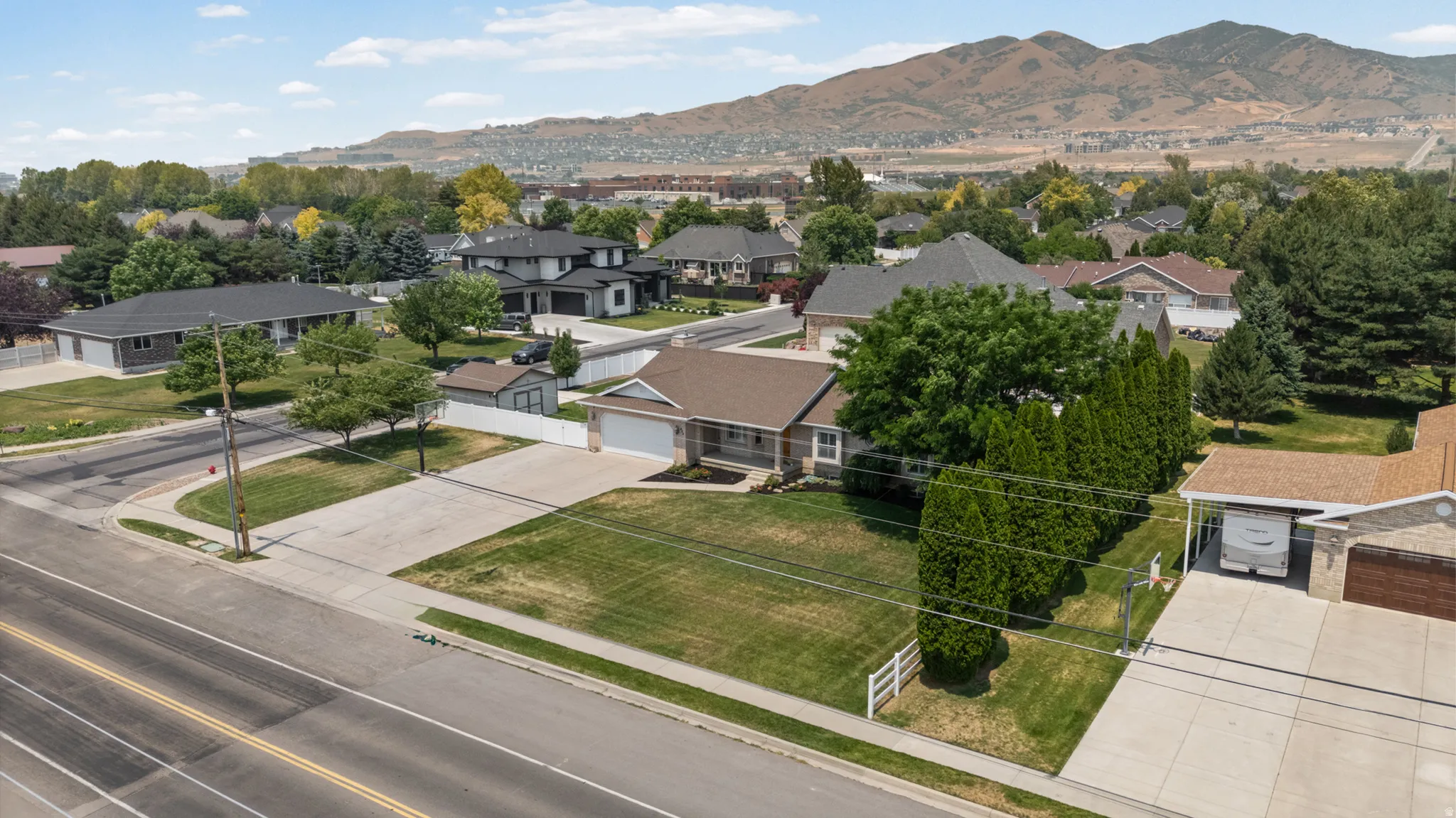 Aerial perspective of a single-story residence featuring a brown shingle roof and an attached garage