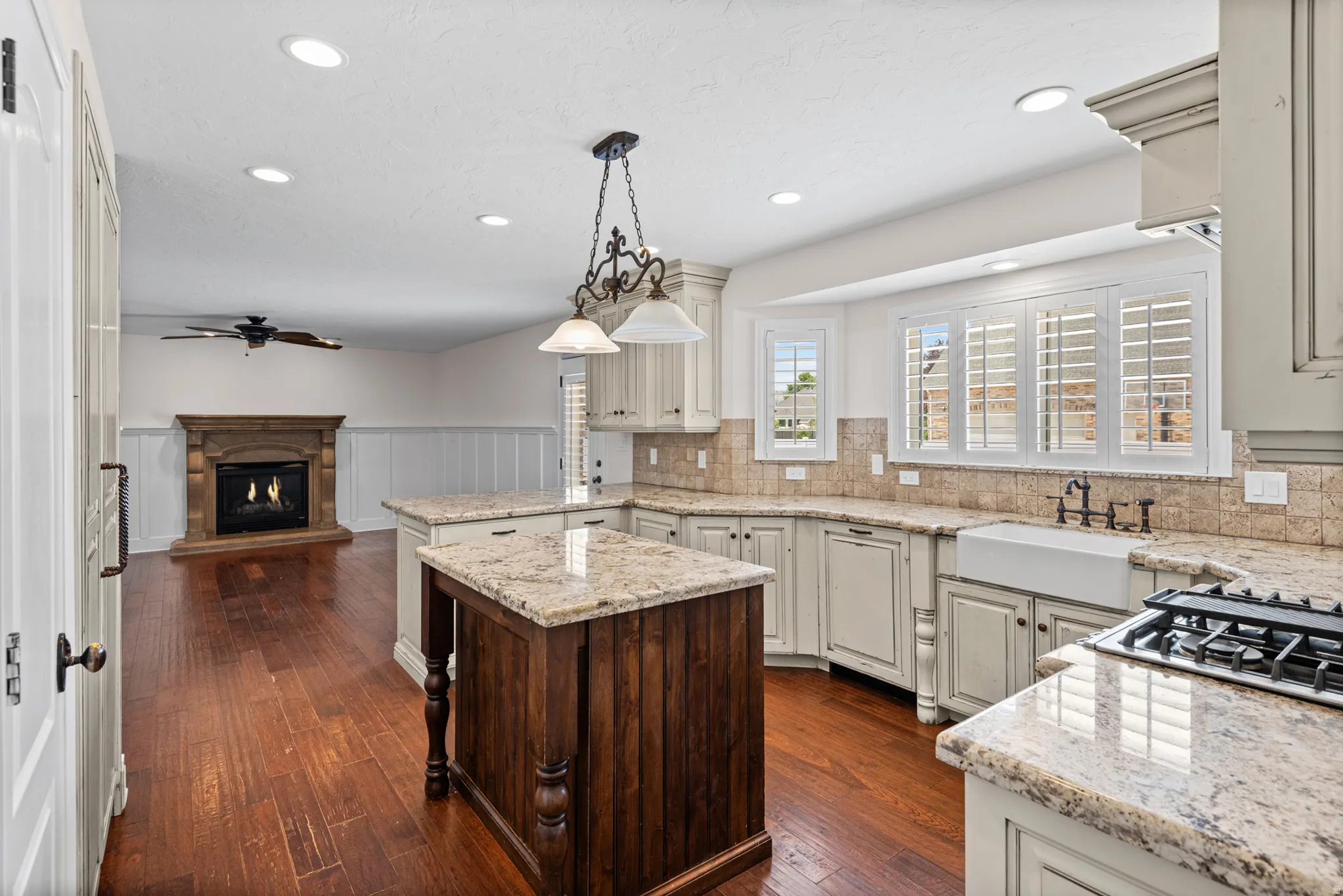Kitchen featuring light-toned cabinetry, granite countertops, and a farmhouse-style sink