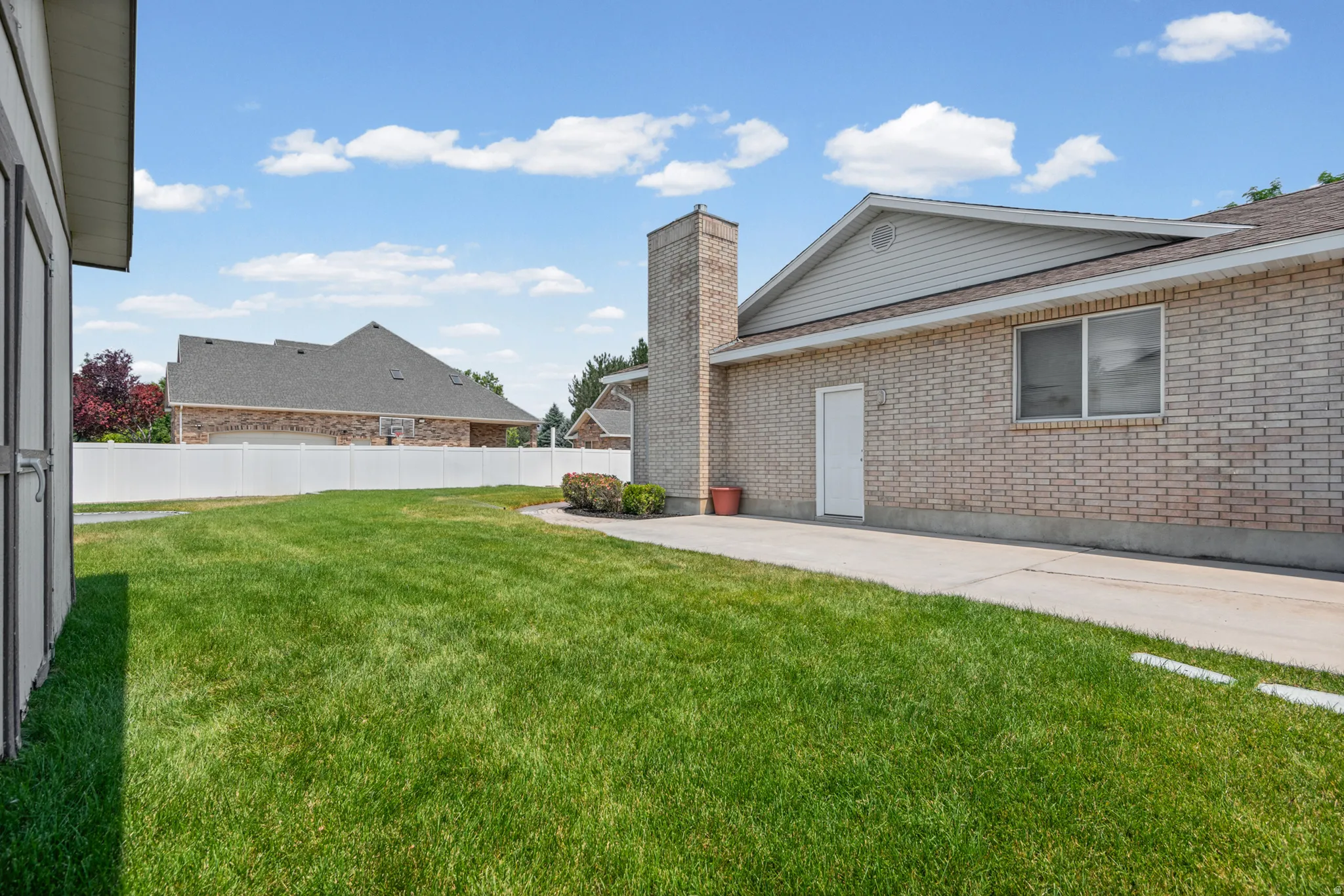 Expansive green lawn with a white vinyl fence