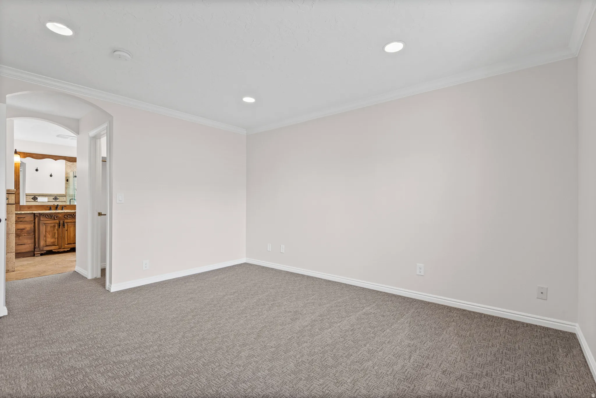 Spacious room featuring neutral carpeting and light-toned walls
