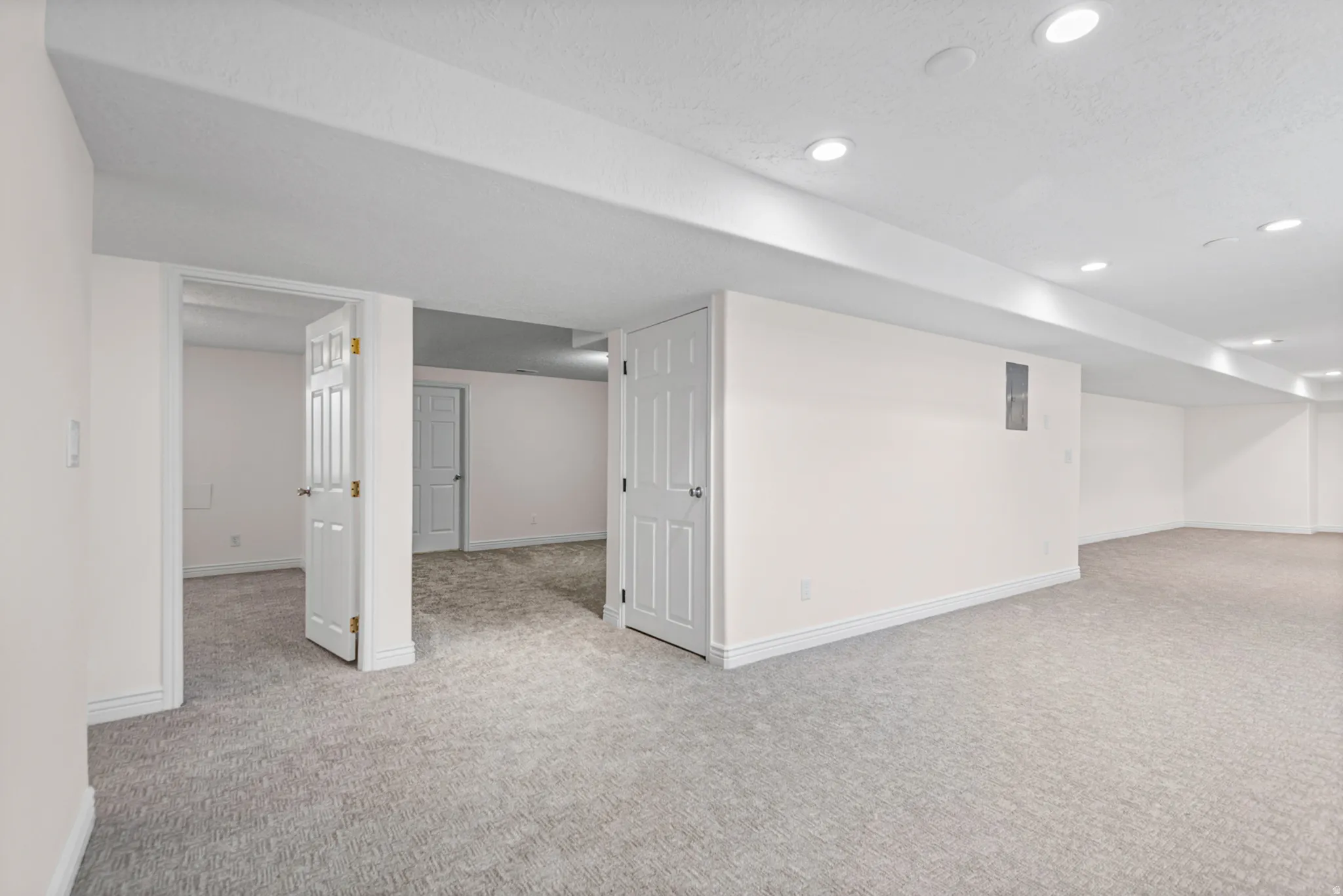 Spacious finished basement featuring recessed lighting, light-toned carpeting, white trim, and multiple doorways