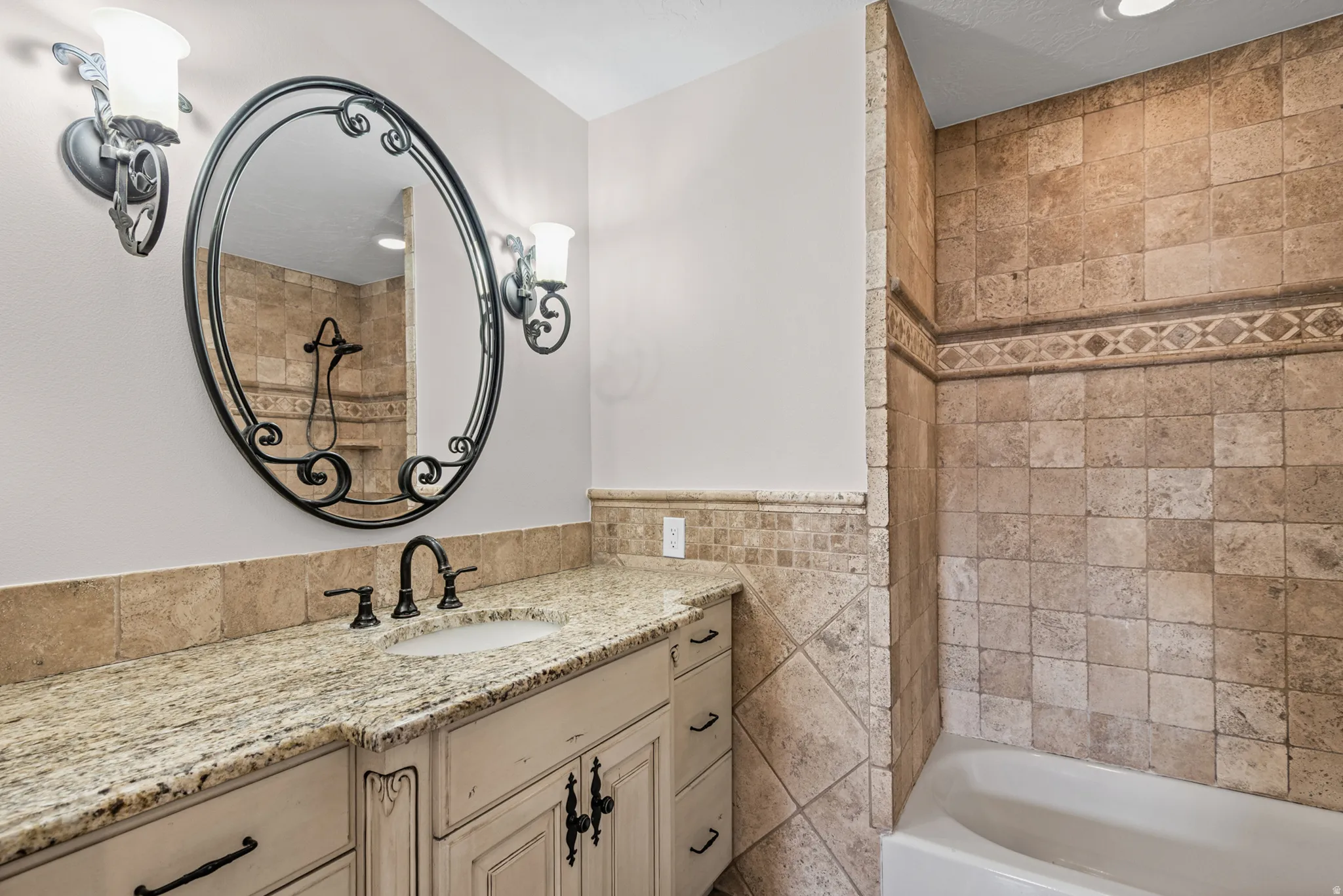 Bathroom vanity featuring a light-toned granite countertop and an undermount sink