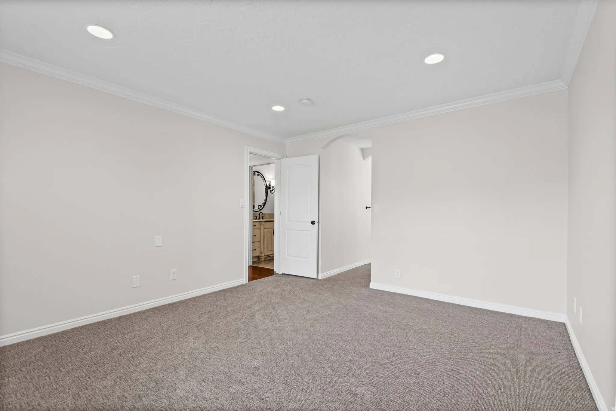 Carpeted room with recessed lighting and crown molding