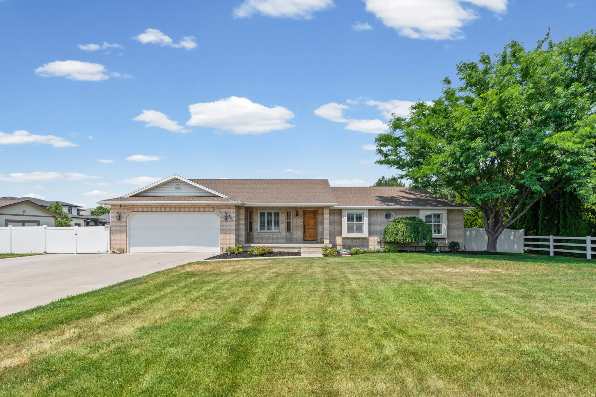 Ranch-style residence featuring a brick facade, attached two-car garage, and a concrete driveway