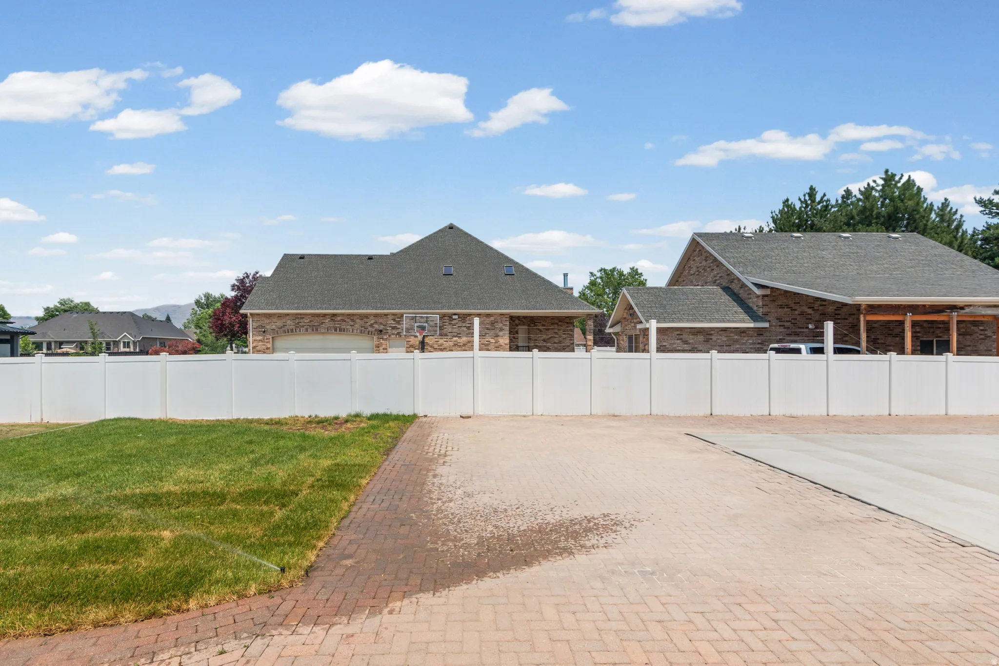 Expansive outdoor space featuring a paver patio and a partially sodded lawn