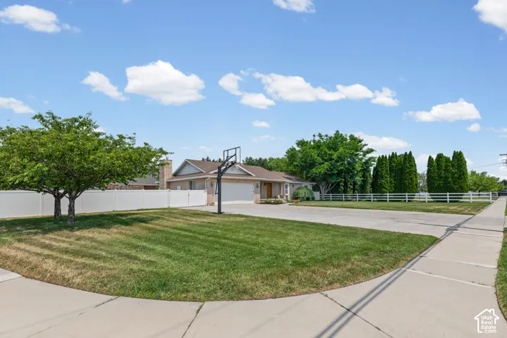 Ranch-style exterior with a two-car garage, featuring a concrete driveway and sidewalk