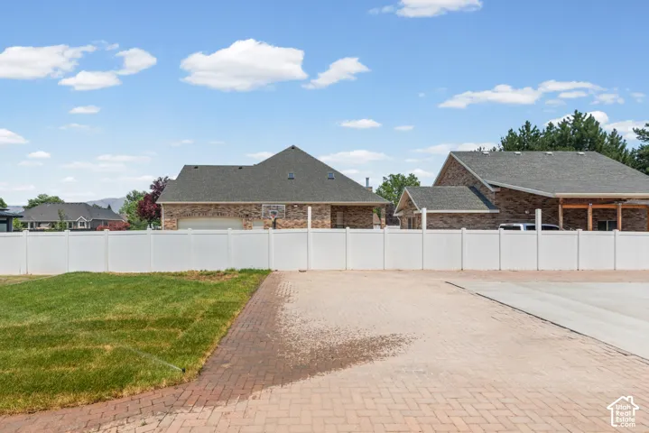 Expansive outdoor space featuring a paver patio and a partially sodded lawn