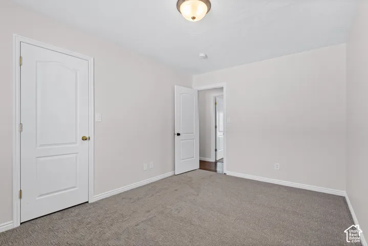 Neutral-toned room featuring a textured gray carpet and white baseboards