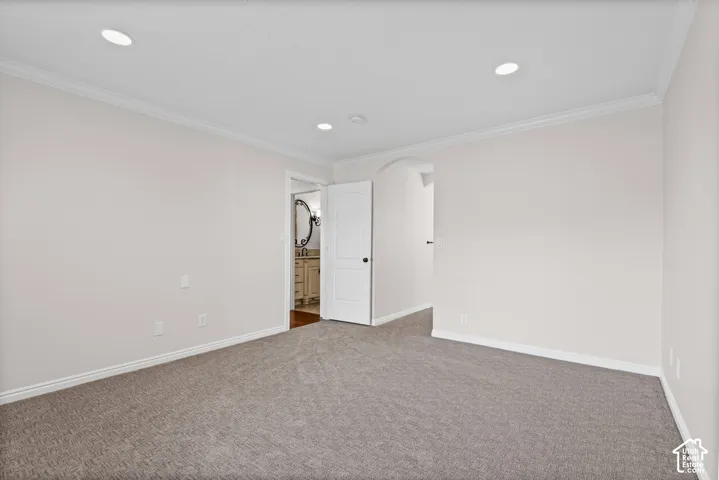 Carpeted room with recessed lighting and crown molding