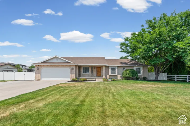 Ranch-style residence featuring a brick facade, attached two-car garage, and a concrete driveway