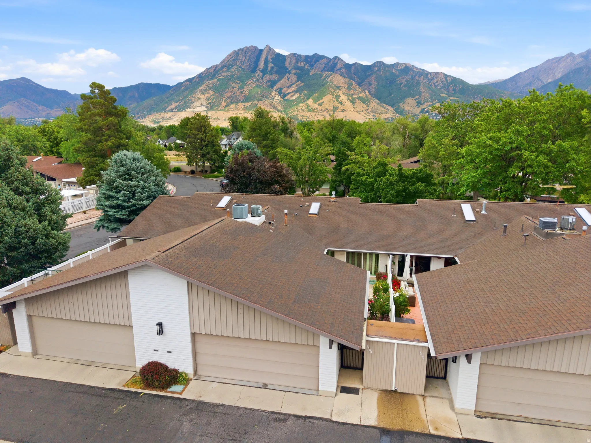 Multi-unit property with a brown shingle roof and tan siding