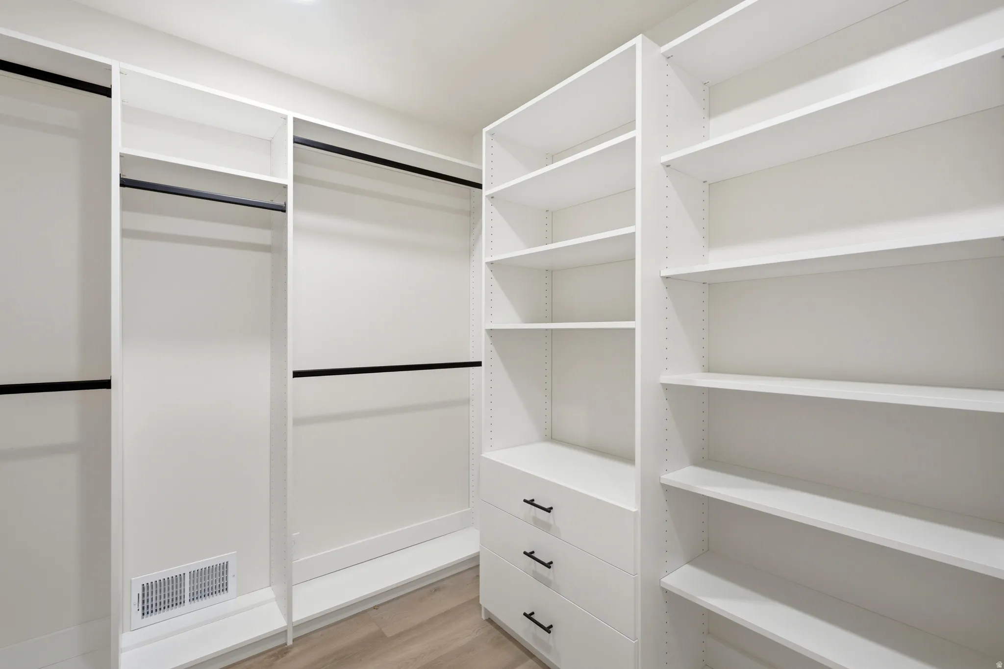 Custom closet system with multiple white shelving units and integrated drawers