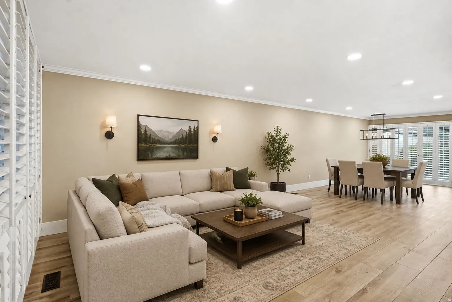 Expansive living and dining areas featuring wood-finish flooring, recessed lighting, and crown molding