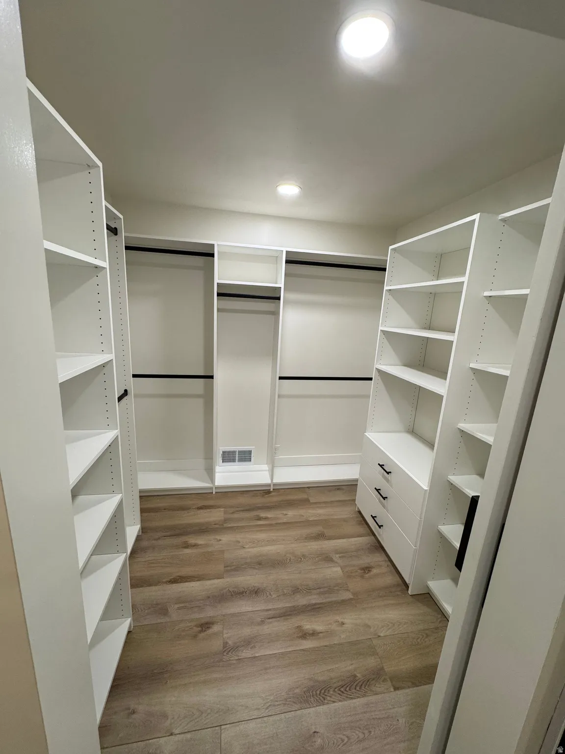 Custom closet system featuring extensive shelving and hanging rods