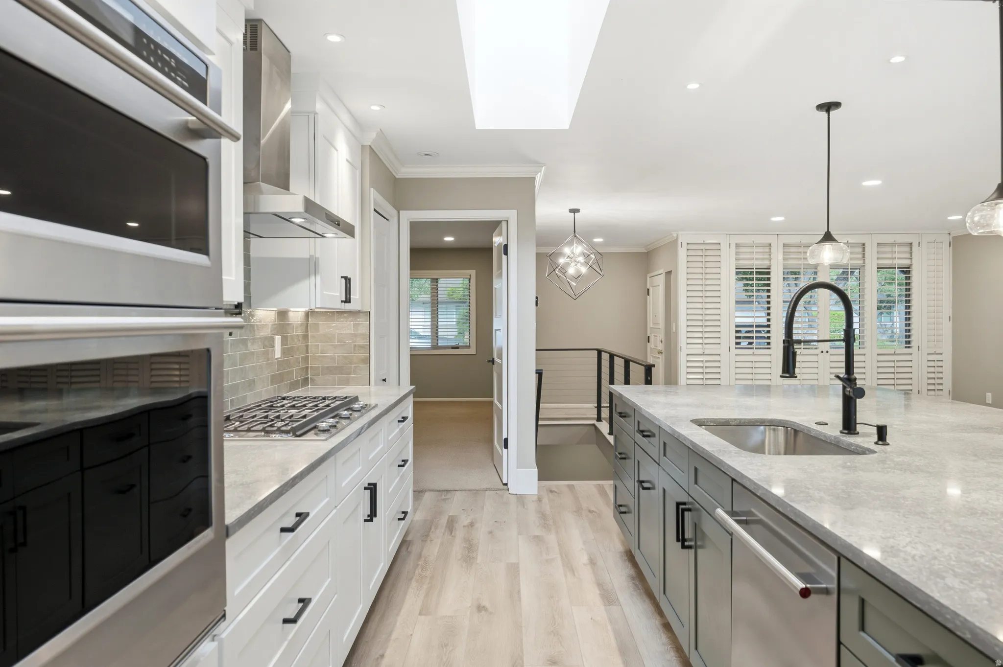Contemporary kitchen featuring an expansive island with an undermount sink and gooseneck faucet