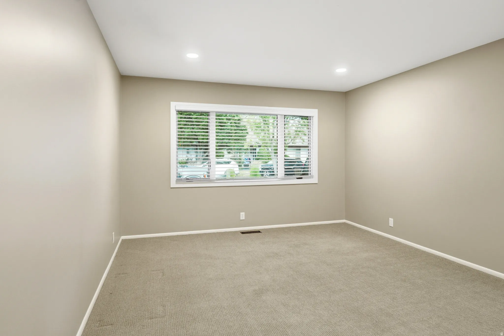 Neutral-toned walls complement plush carpeting