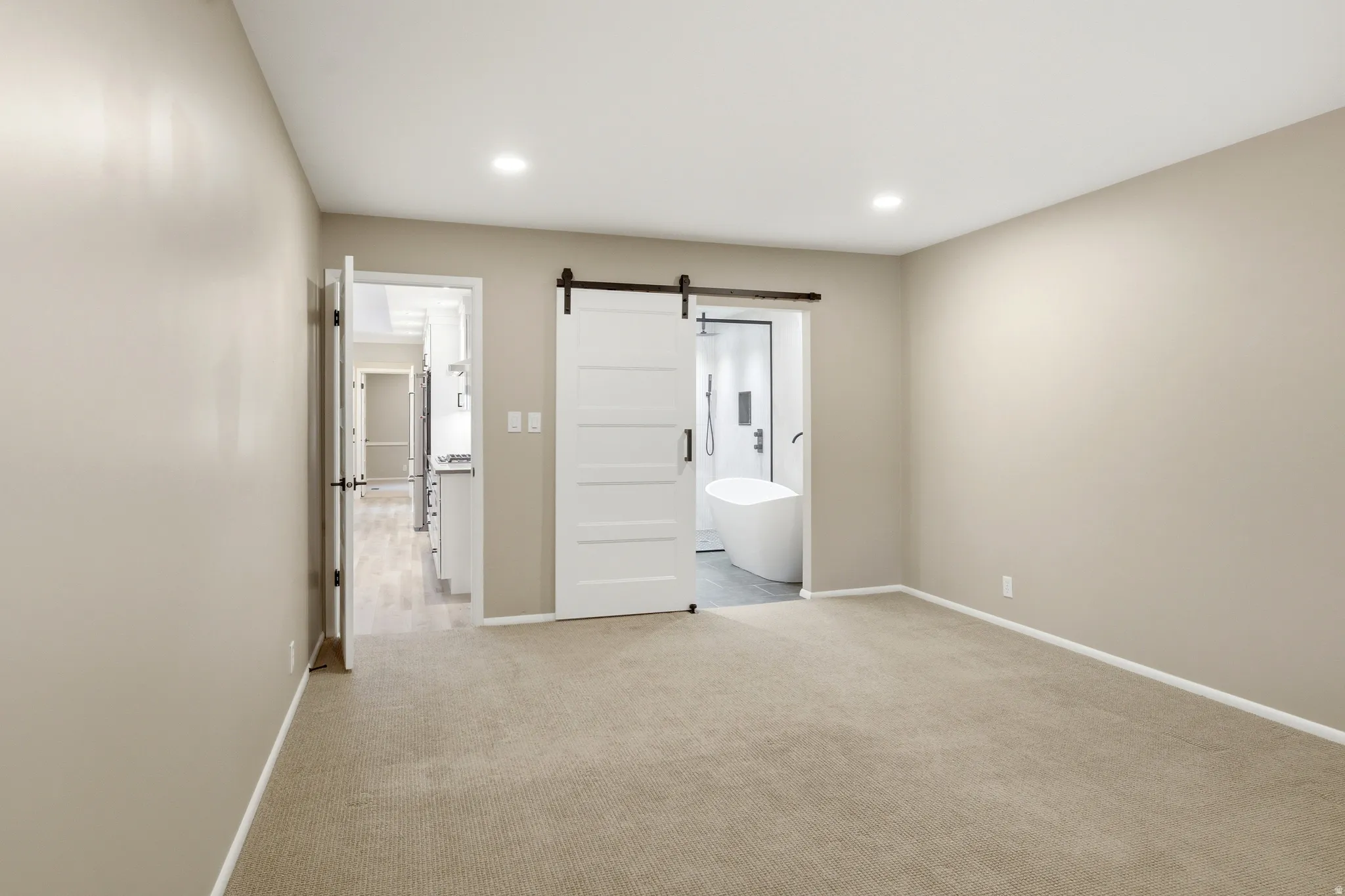 Carpeted room with recessed lighting and neutral wall tones