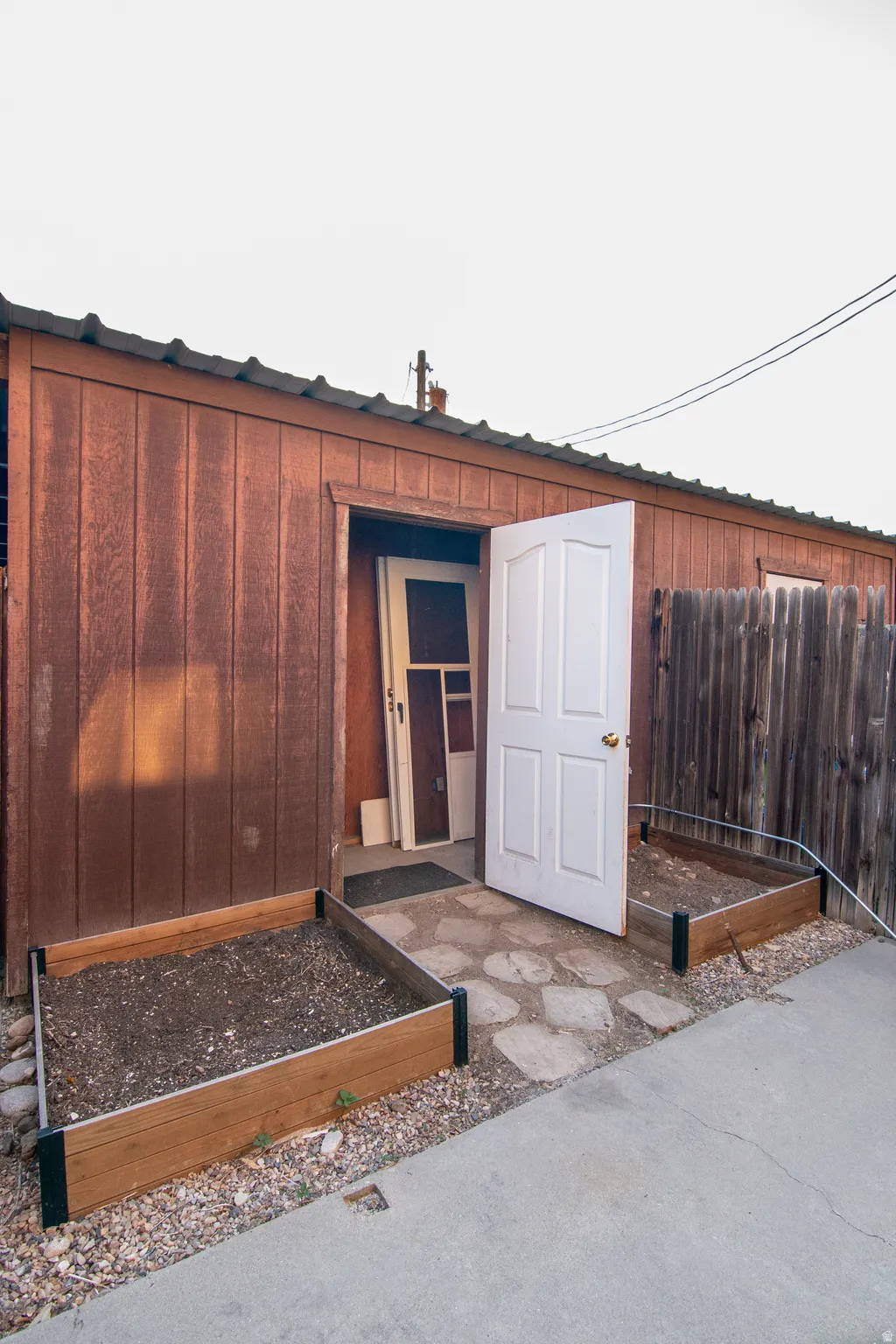 Red-hued board and batten siding structure with a metal roof