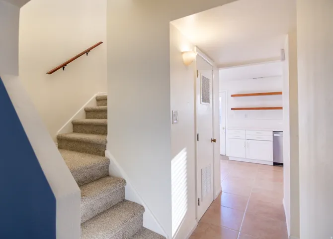 Carpeted staircase with a wood handrail