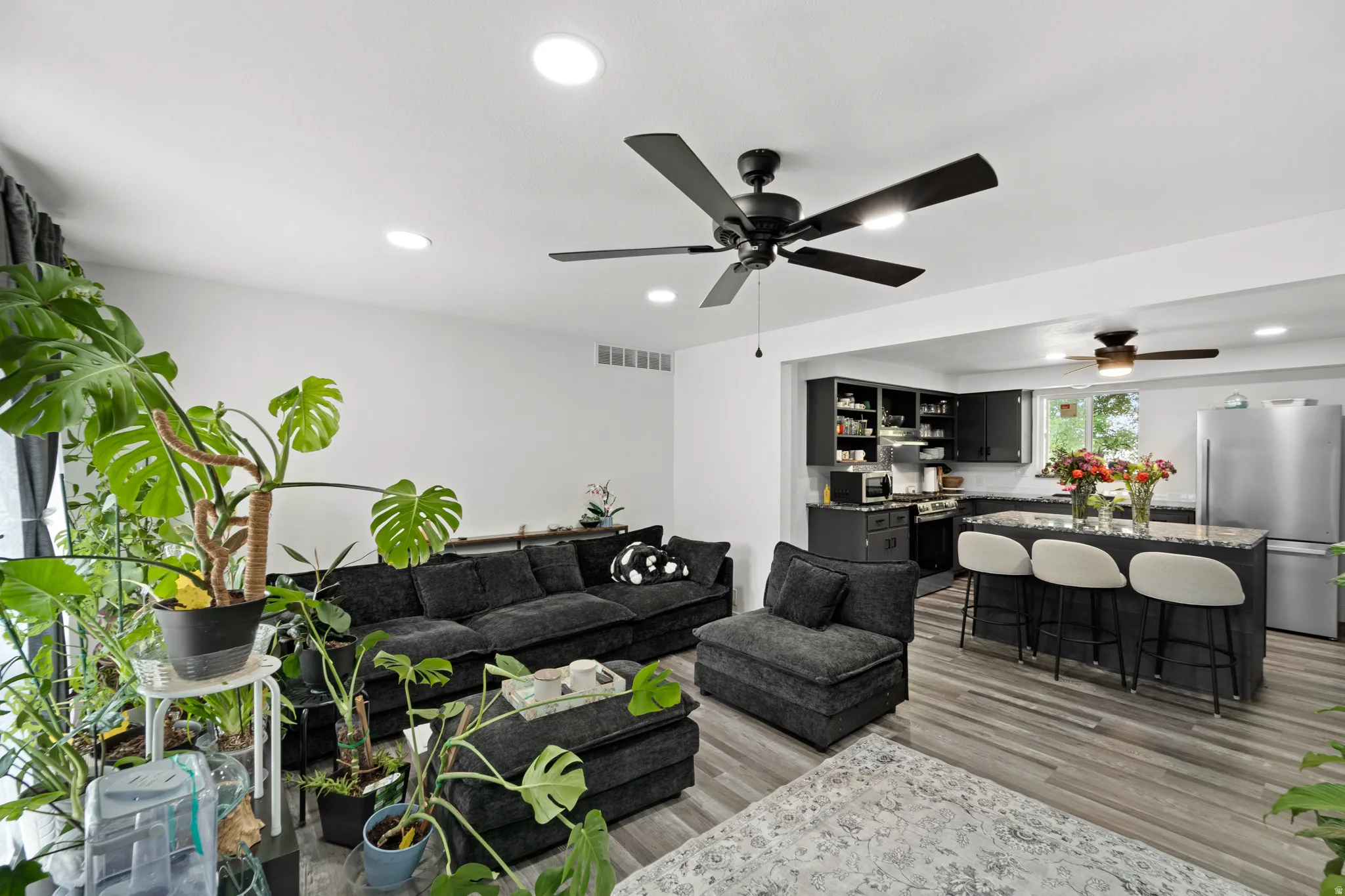 Open-concept living space featuring wood-finish flooring and recessed lighting