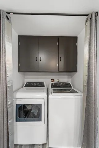 Dedicated laundry area featuring a white washer and dryer pair