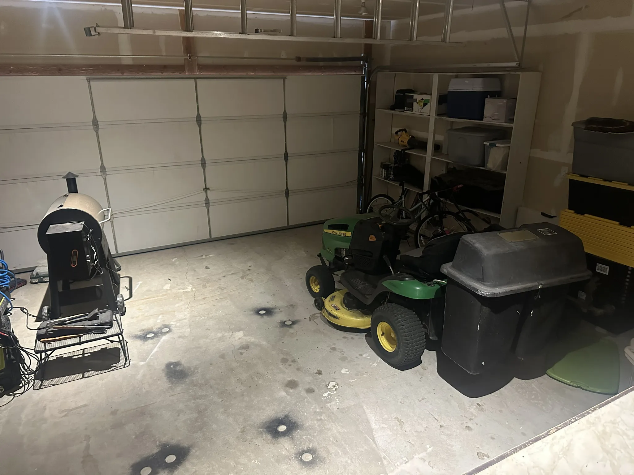 Attached garage featuring a sectional overhead door, concrete flooring, and built-in shelving