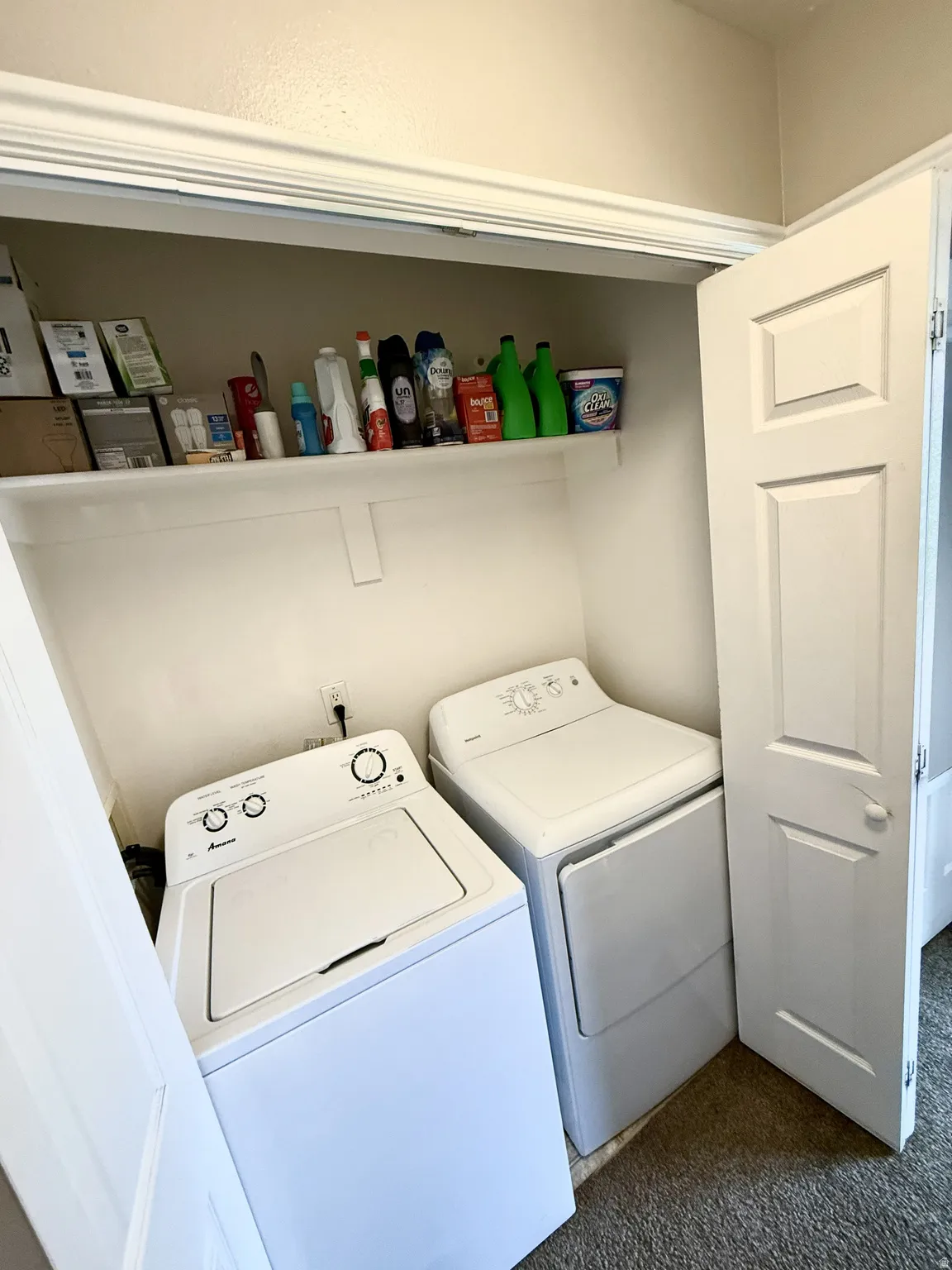 Dedicated laundry closet with a top-load washer, a front-load dryer, and an upper storage shelf