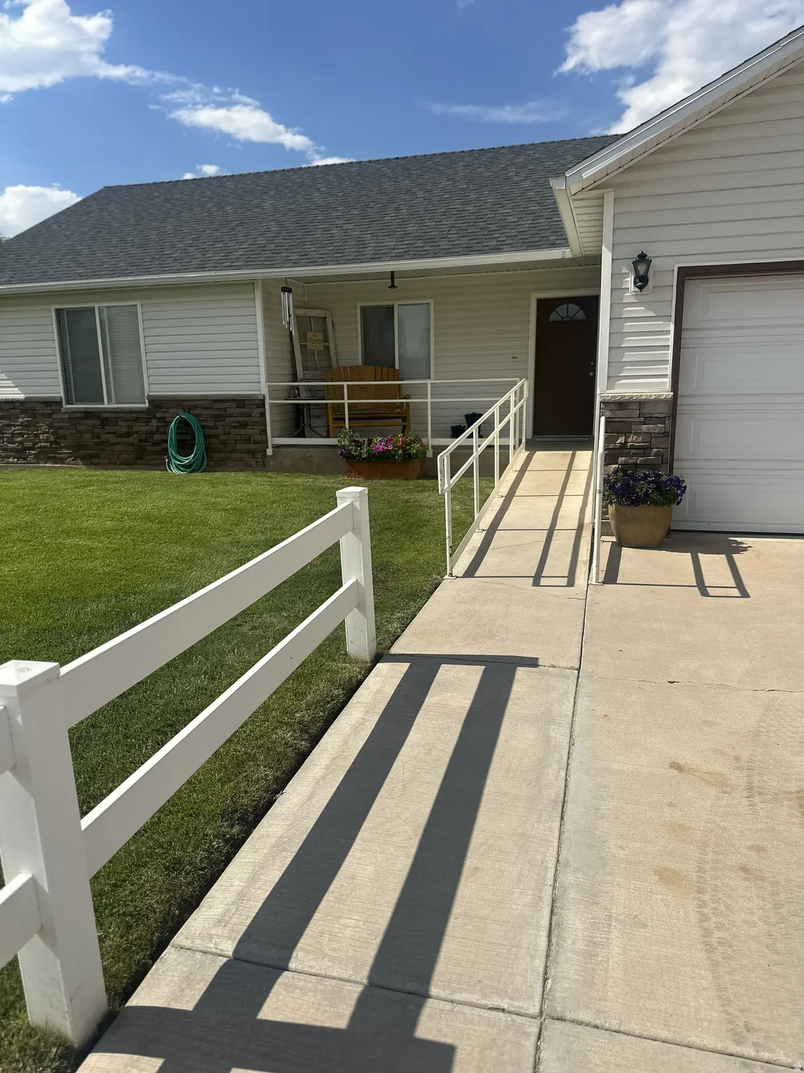 Ranch-style exterior with stone veneer accents and light-colored siding