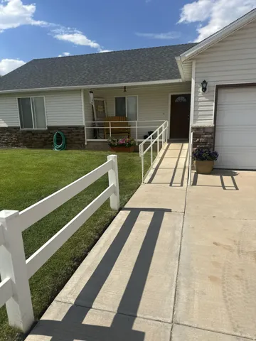 Ranch-style exterior with stone veneer accents and light-colored siding