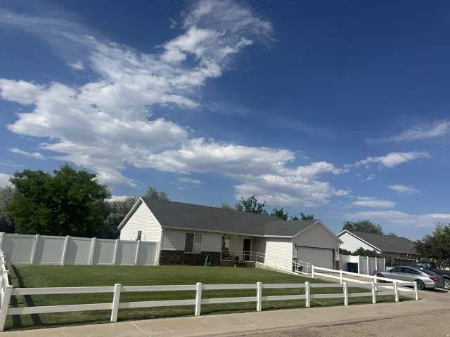 Ranch-style residence featuring white siding and a dark shingle roof