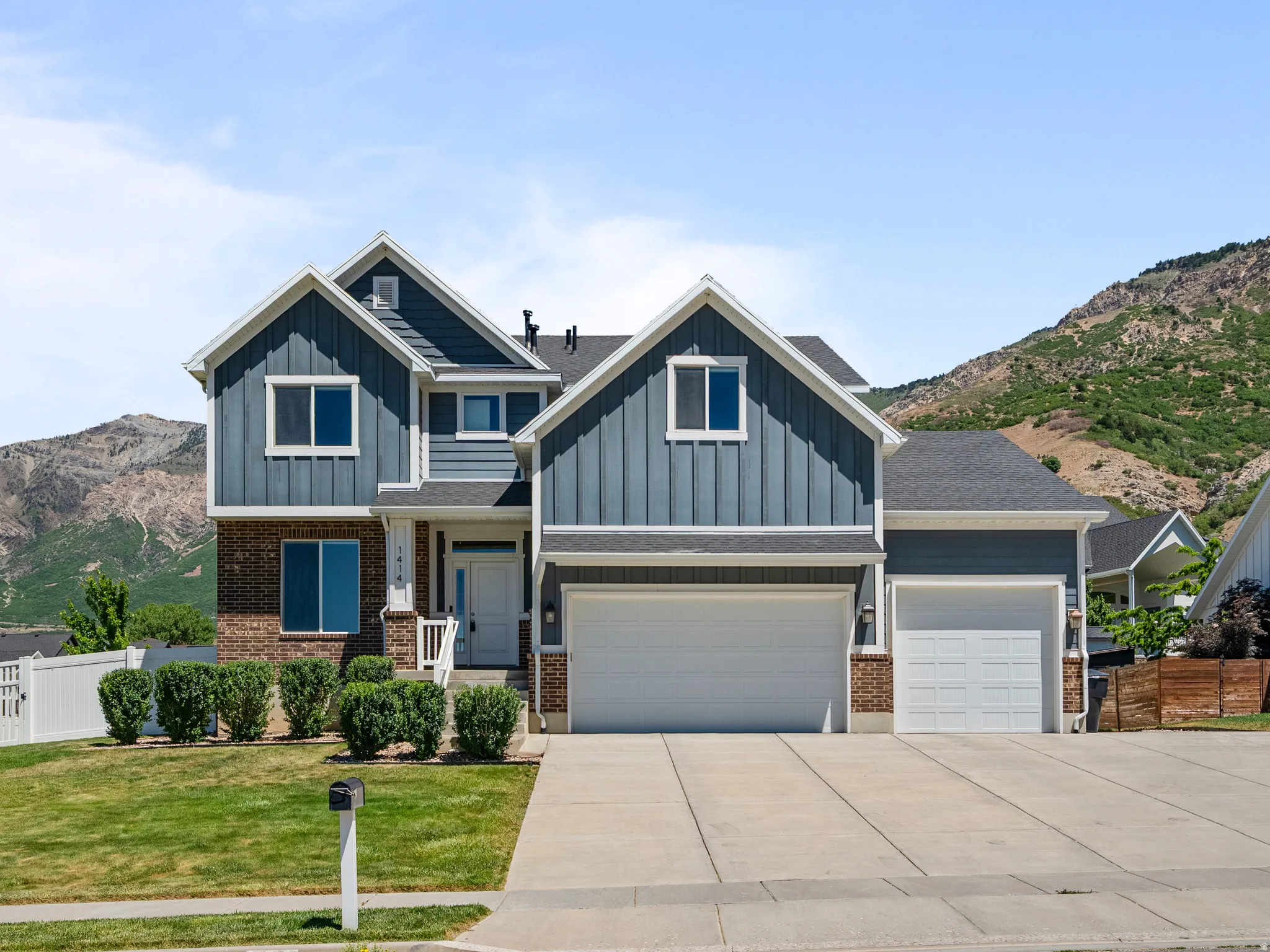 Two-story exterior featuring blue vertical siding and brick accents